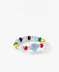 Dettaglio anello in argento S925 con perline colorate e ciondolo a fiore azzurro