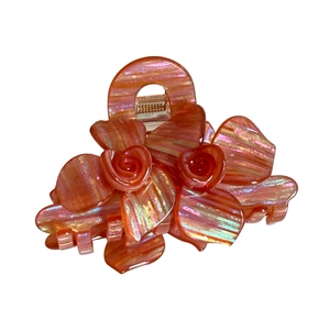 Elegant orange flower hair claw clip with sparkly striped texture on white background