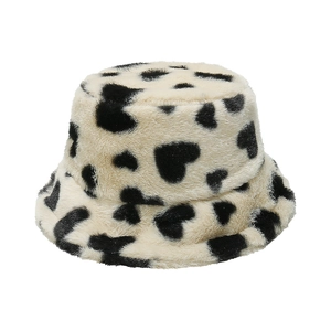 Detail shot of winter faux rabbit fur bucket hat with cute black heart cow print texture