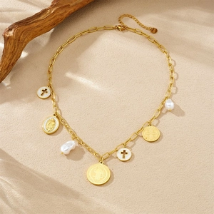 Detailed shot of golden necklace with cross pendants, Virgin Mary icon and baroque pearls