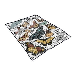 Detail of soft white flannel blanket featuring colorful butterfly patterns and black hem edging
