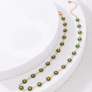 Macro shot of colorful daisy necklace with green petals and golden chain on a white stand