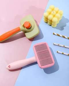 Détail de la brosse autonettoyante pour animaux avec picots protégés et bouton d'éjection