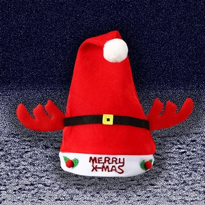 Detail of red plush Christmas hat with reindeer antlers and Merry X-mas embroidery