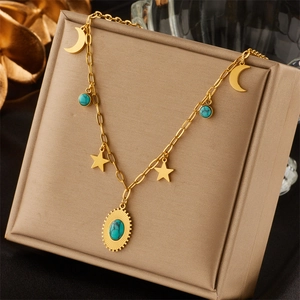 Bohemian gold necklace with turquoise pendant featuring stars and moons on a jewelry box