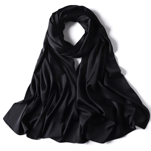 Detail of black satin scarf showing smooth silk texture and elegant fabric draping