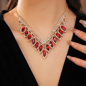 Detail shot of elegant gold necklace featuring red teardrop stones and shimmering crystals