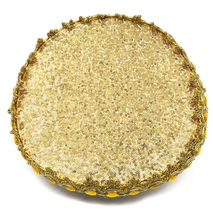 Macro view of gold sequin wedding tray with ornate woven trim and yellow gemstones