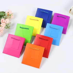Detailed view of colorful paper gift bags with twisted handles in eight vibrant colors