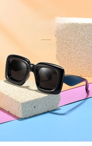 Détail de lunettes de soleil enfant à monture carrée noire et branches colorées