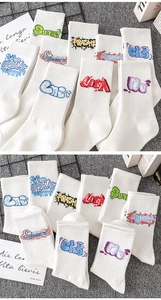 Detailed close-up of white crew socks featuring colorful graffiti patterns and typography