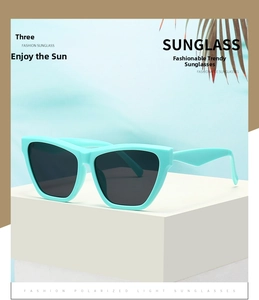 Detail of mint green cat eye sunglasses with polarized lenses on a summer beach background