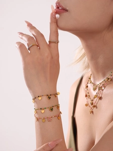 Detailansicht des goldenen Schmucksets mit bunten Herzanhängern und Schicht-Halsketten