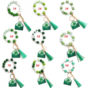 Flat lay view of 9 St. Patrick's Day silicone bead bracelets with clover pendants