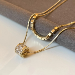 Close-up of 18k gold plated double cylinder pendant with pavé set cubic zirconia stones