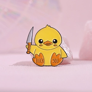 Creative enamel pin featuring a cute yellow duck holding a knife and Duck You lettering