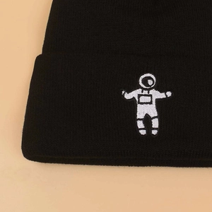 Close-up of astronaut embroidery on a black ribbed knit beanie for winter
