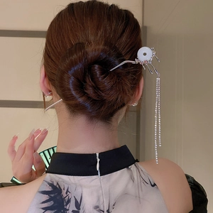Detailed view of silver butterfly hair pin with tassels and diamond accents on hair