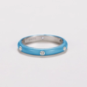 Macro detail of a light blue enamel ring band with sparkling inset zircon stones