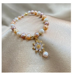 Macro detail of irregular freshwater pearl bracelet with micro-set zircon sunflower pendant