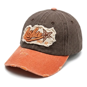 Detail of vintage washed baseball cap with contrast patch embroidery and distressed brim