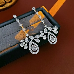 Detail of silver long chain tassel earrings with pear drop zircon in a black velvet box