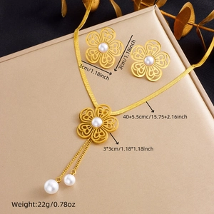 Golden flower and pearl jewelry set including necklace and earrings on a gift box