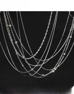 Macro display of diverse S999 sterling silver chain styles on professional black background
