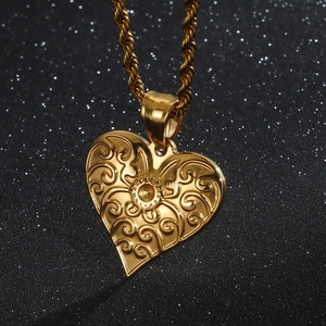 Retro gold heart pendant necklace with swirl engraving and twisted chain on dark background