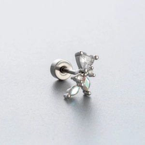 Detailed macro view of silver titanium steel butterfly earring with heart-shaped zircon