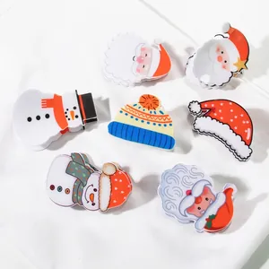 Festive Christmas hair clips set with Santa, snowman and tree on white fabric background