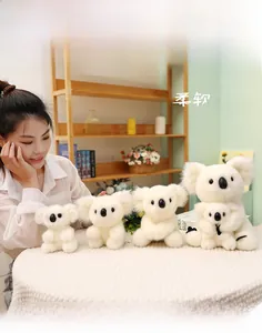Detailed view of soft beige plush koala dolls in four sizes on a cozy knitted surface