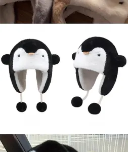 Detail of penguin plush trapper hat with furry earflaps and cute pom-poms for winter