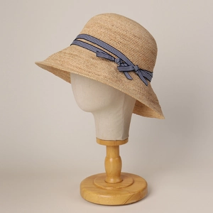 Elegant straw sun hat with blue striped ribbon and bow for summer beach vacation