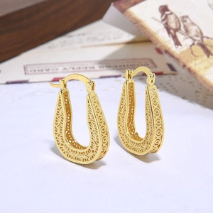 Detailed close-up of 18K gold plated U-shaped earrings with intricate hollow filigree patterns