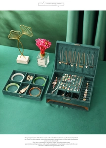Detailed interior view of a large green velvet jewelry box with organized storage compartments