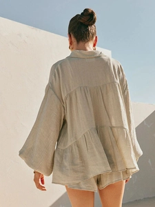 Back view of beige linen set featuring puff sleeves and tiered ruffle hem blouse