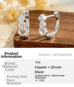 Detailed view of silver violin shape hoop earrings with cubic zirconia and wood texture