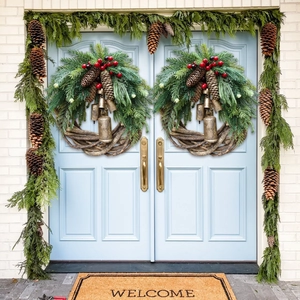 Detail of Christmas wreath with vintage metal bells, pine cones and red berries on door