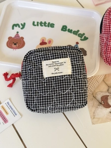 Detailed shot of quilted heart pattern and black and white grid fabric on storage pouch