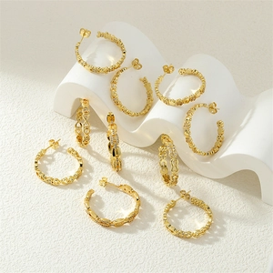 Detailed macro view of chain-style gold hoop earrings with zircon pavé and geometric hollows