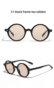Detail view of vintage round sunglasses with black frames and tea-colored lenses