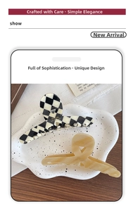 Macro detail of acetate shark hair clips with checkered pattern and gold label