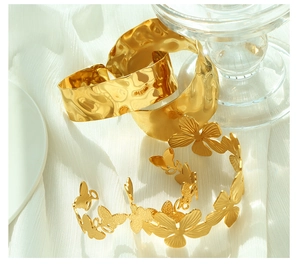 Detail of hammered texture on gold titanium steel cuff bracelets and floral choker
