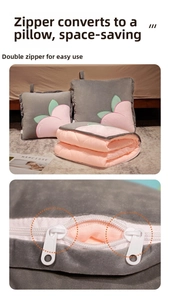 Close-up of the smooth dual-zipper detail on the peach patterned 2-in-1 pillow blanket