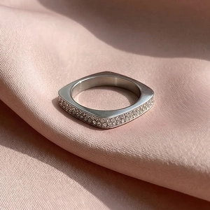 Détail d'une bague carrée argentée sertie de plusieurs rangées de zircons brillants