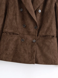 Détail d'un blazer en daim vert olive avec boutons à double boutonnage et texture douce