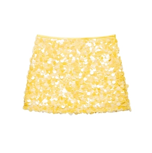 Detail showing layered yellow sequins on a slim fit mini skirt with shimmering texture