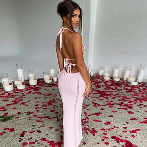 Completo rosa in maglia con top a schiena scoperta e gonna a spacco su petali di rosa