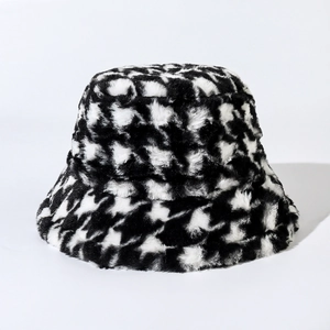 Close-up of fluffy black and white houndstooth plush bucket hat with soft faux fur texture
